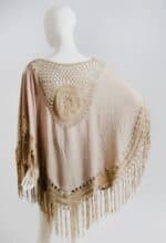 Beige fringed poncho displayed on a mannequin against a white background.